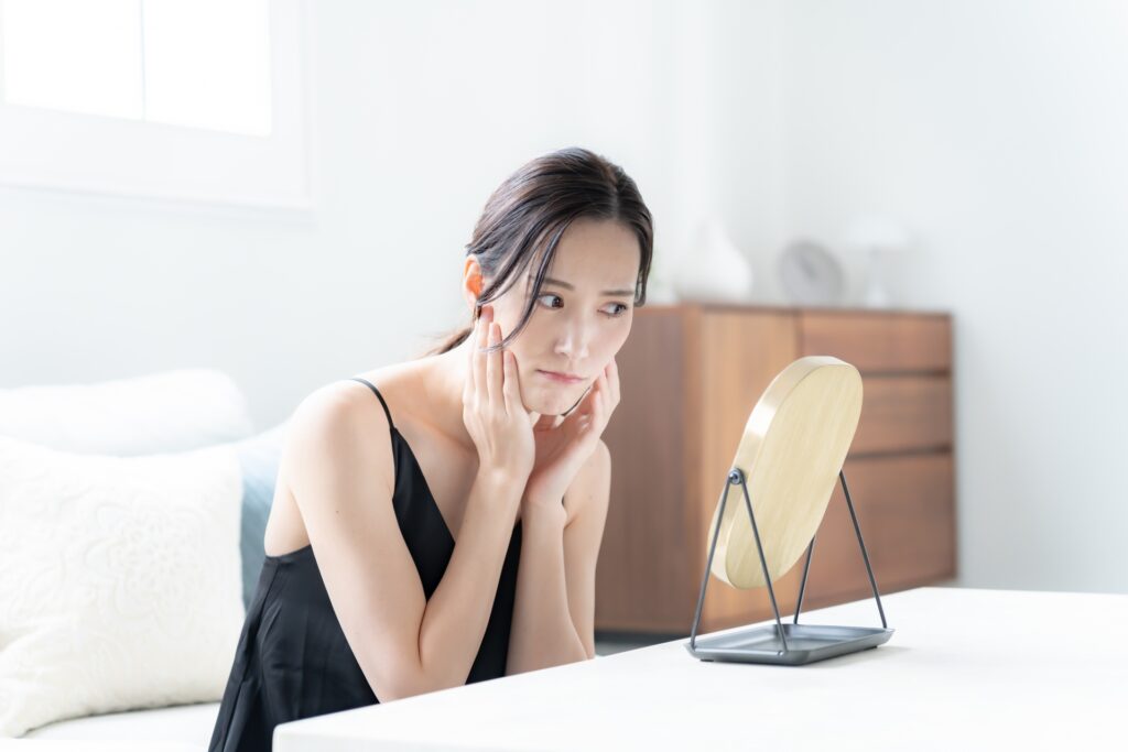 肝斑がレーザーで悪化することはあるのか:鏡を覗き込む女性の写真