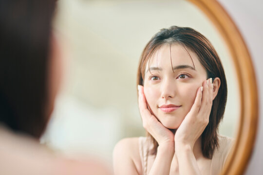 肝斑治療のまとめ:鏡を見つめる女性の写真